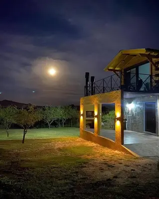 a house at night with the moon in the sky at Terrazas del Algarrobo in Santa Rosa de Calamuchita