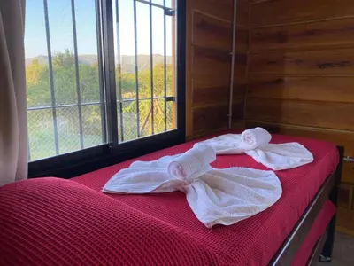 a bed with towels on it in a room with a window at Terrazas del Algarrobo in Santa Rosa de Calamuchita