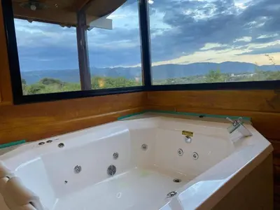 a bath tub in a room with a large window at Terrazas del Algarrobo in Santa Rosa de Calamuchita