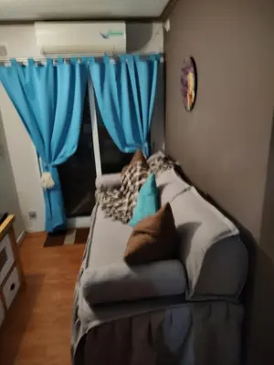 a couch in a room with blue curtains at Apartamento Baykus in Cordoba