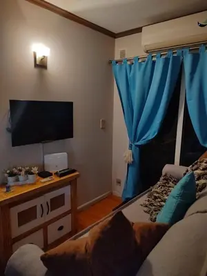 a living room with a television and blue curtains at Apartamento Baykus in Cordoba