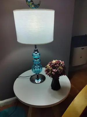 a table with a lamp and a vase of flowers on it at Apartamento Baykus in Cordoba