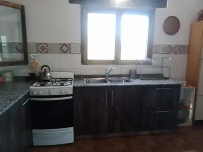 a kitchen with a stove and a sink at Casa de campo La Chunia in Villa Cura Brochero