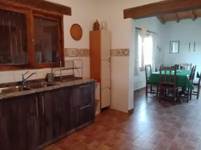 a kitchen with a sink and a kitchen with a table at Casa de campo La Chunia in Villa Cura Brochero