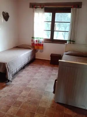 a room with two beds and a window at Casa de campo La Chunia in Villa Cura Brochero