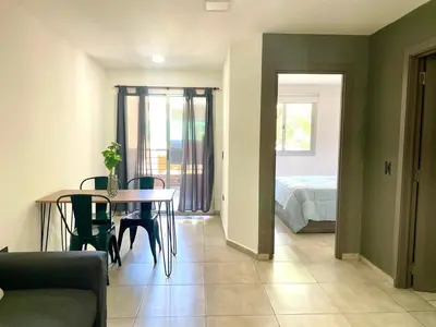 a living room with a table and a bedroom at Nova Vita in Cordoba