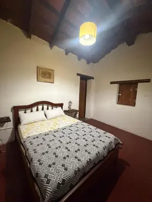 a bedroom with a bed with a black and white comforter at Casita de campo in Las Calles
