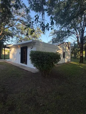 a small white building in a yard with a tree at Casita de campo in Las Calles