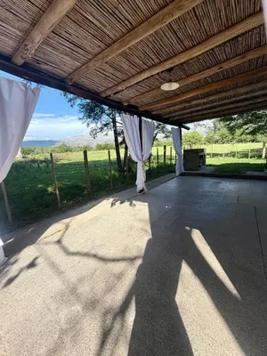 a covered patio with a view of a field at Casita de campo in Las Calles