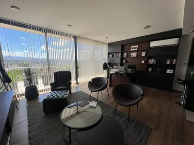 a living room with chairs and a table and a large window at Residencia Premium con Vista Panorámica y Pileta Climatizada in Villa Carlos Paz