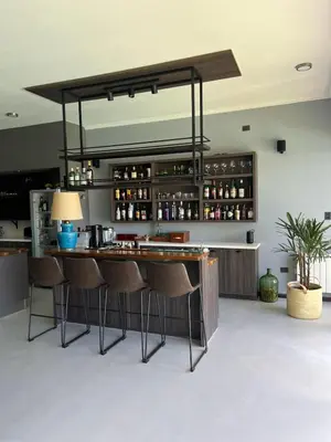 a bar in a room with some chairs and a counter at Residencia Premium con Vista Panorámica y Pileta Climatizada in Villa Carlos Paz