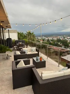a rooftop patio with couches and tables and lights at Residencia Premium con Vista Panorámica y Pileta Climatizada in Villa Carlos Paz