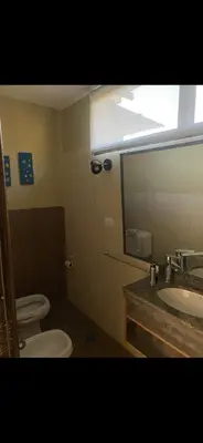 a bathroom with two toilets and a sink and a mirror at Jardines de estrellas in Santa Rosa de Calamuchita