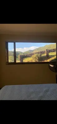 a bedroom with a window with a bed and a view at Jardines de estrellas in Santa Rosa de Calamuchita