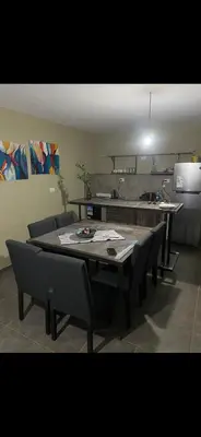 a dining room with a table and chairs and a kitchen at Jardines de estrellas in Santa Rosa de Calamuchita