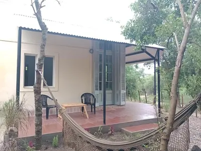 a porch with a hammock in front of a house at Tacuarita in Los Hornillos