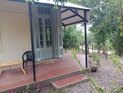a porch with a bench and an open door at Tacuarita in Los Hornillos