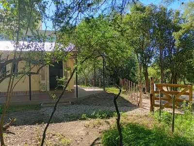 a garden with a wooden bench in front of a building at Tacuarita in Los Hornillos