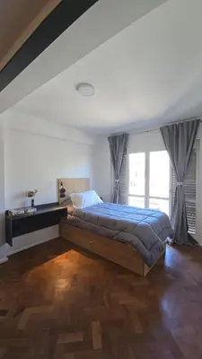 a bedroom with a bed and a large window at ALV26 4G -Departamento Sobremonte in Cordoba