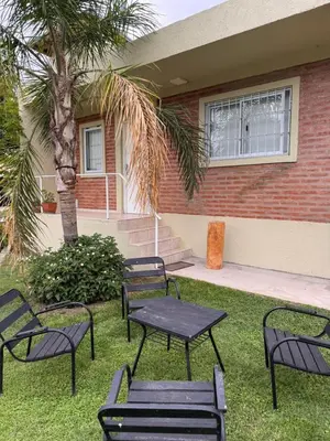 a group of black tables and chairs in front of a house at Sol y Río in Villa Carlos Paz