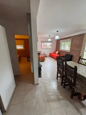 a living room with a couch and a table and chairs at Sol y Río in Villa Carlos Paz