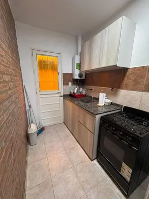 a kitchen with a black stove and a window at Sol y Río in Villa Carlos Paz