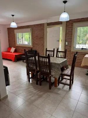 a dining room with a table and chairs and a couch at Sol y Río in Villa Carlos Paz