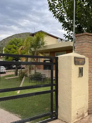 a black fence with a gate with a sign on it at Sol y Río in Villa Carlos Paz