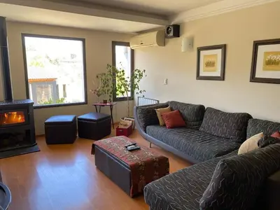 a living room with a couch and a fireplace at Casa de Categoria, Villa Del Lago, Cap 8 pers in Villa Carlos Paz