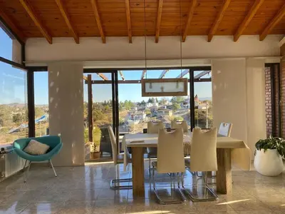 a dining room with a table and chairs and windows at Casa de Categoria, Villa Del Lago, Cap 8 pers in Villa Carlos Paz