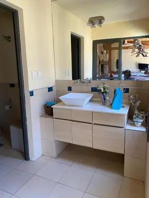 a bathroom with a sink and a mirror at Casa de Categoria, Villa Del Lago, Cap 8 pers in Villa Carlos Paz