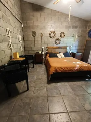 a bedroom with a bed and a table and chairs at El Algarrobo Casa de campo en Cabalango in Cavalango