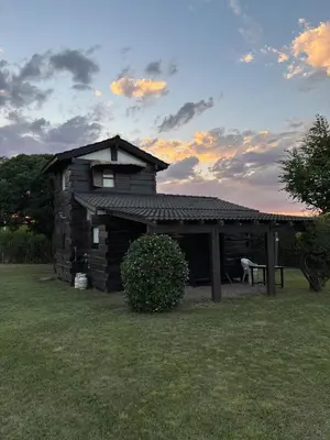 a log cabin with a bench in the yard at Cabañas El Atalaya in Villa Rumipal