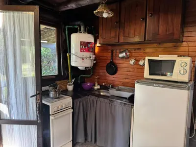 a kitchen with a refrigerator and a microwave at Cabañas El Atalaya in Villa Rumipal