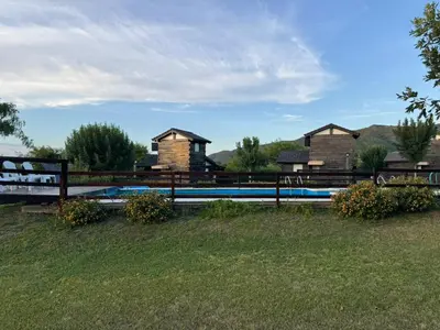a yard with a fence and some houses at Cabañas El Atalaya in Villa Rumipal