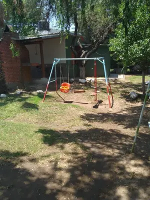 a swing set in a yard with a tree at casa para 12 personas en bialet in San Roque