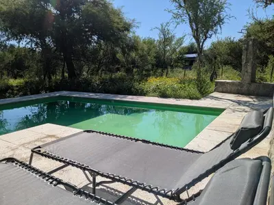 a swimming pool with a chaise lounge next to a pool at Posada Abrazo Serrano en Carpintería in Carpintería