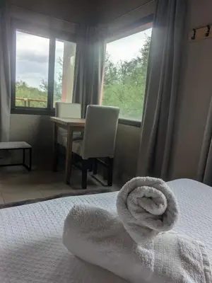 a bedroom with a bed and a table and window at Posada Abrazo Serrano en Carpintería in Carpintería