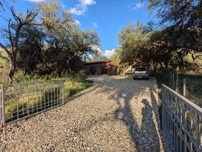 a driveway leading to a house with a fence at Posada Abrazo Serrano en Carpintería in Carpintería