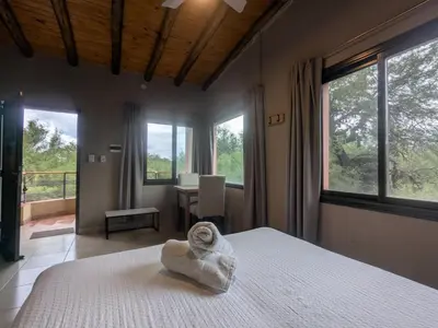 a bedroom with a bed with a towel on it at Posada Abrazo Serrano en Carpintería in Carpintería