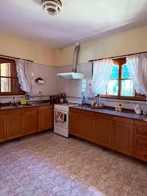 a large kitchen with wooden cabinets and a stove at Casa de campo Marines in San Antonio de Arredondo