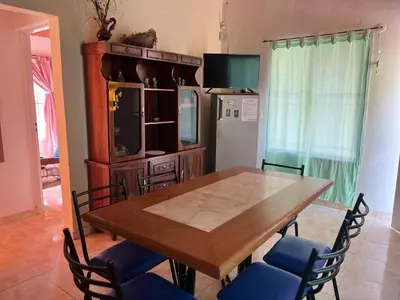 a dining room table with chairs and a refrigerator at Timtaya in Barrio Parque El Corcovado
