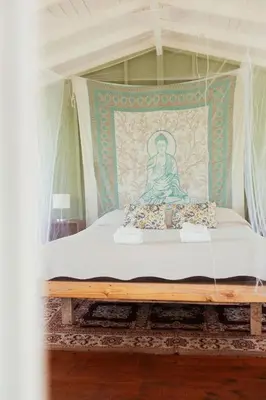 a bed with a painting of a buddha on it at Glamping Traslasierra Carpa Sur in San Javier