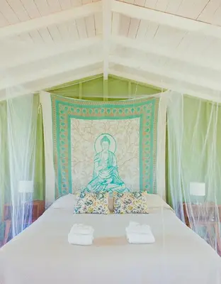 a bed with a painting of a woman on it at Glamping Traslasierra Carpa Sur in San Javier