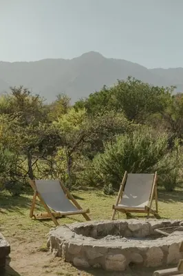 two lounge chairs sitting next to a fire pit at Glamping Traslasierra Carpa Sur in San Javier