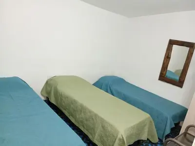two beds in a room with a mirror on the wall at Hermosa Casa equipada a metros del Río Cosquín in Bialet Massé