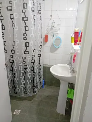 a bathroom with a shower curtain and a sink at Hermosa Casa equipada a metros del Río Cosquín in Bialet Massé