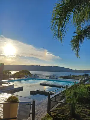a large swimming pool with a view of the water at Colibrí Del Lago in Villa Parque Siquiman