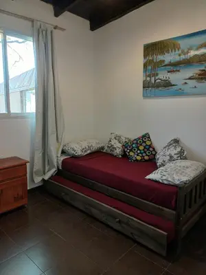a bed in a room with a window at Colibrí Del Lago in Villa Parque Siquiman