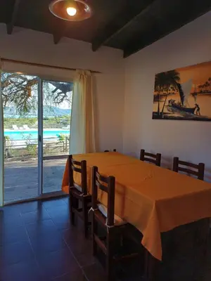 a dining room with a table and a large window at Colibrí Del Lago in Villa Parque Siquiman